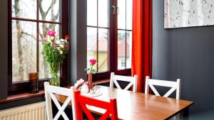 una mesa de comedor con 2 sillas y un jarrón con flores en Hotel Halny, en Karpacz