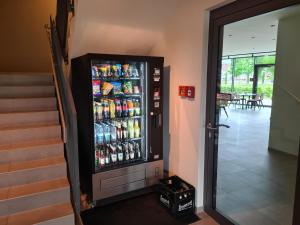 a vending machine filled with drinks in a hallway at KELKO 1A Hotel in Kehl am Rhein