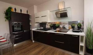 uma cozinha com armários a preto e branco e um lavatório em SWEET HOME FIERA em Bolonha