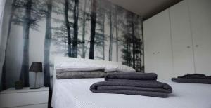um quarto com uma cama com árvores na parede em SWEET HOME FIERA em Bolonha