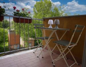 uma varanda com 2 cadeiras, uma mesa e uma janela em SWEET HOME FIERA em Bolonha