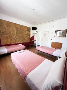 a room with two beds and a table at Hostal La Casa de La Plaza in Madrid