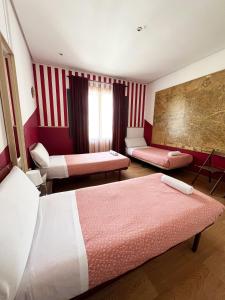 Habitación de hotel con 2 camas y sofá en Hostal La Casa de La Plaza, en Madrid