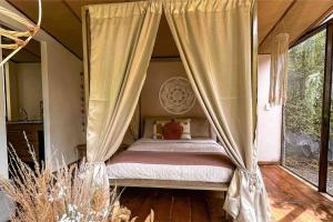 a bedroom with a canopy bed in a tent at Intrepido Glamping in Chinchiná