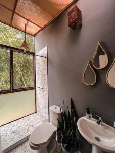 a bathroom with a toilet and a sink and a window at Intrepido Glamping in Chinchiná