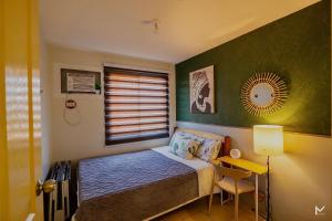 a small bedroom with a bed and a window at CASA ELIRA Aesthetic 2 BR Condo Unit Iloilo in Iloilo City