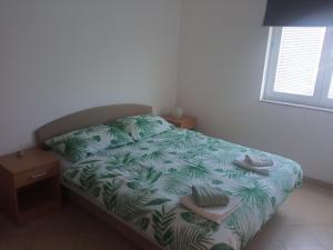 a bedroom with a bed with towels on it at Apartmani Marko & Joso in Biograd na Moru