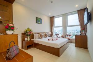 Postel nebo postele na pokoji v ubytování Golden Light Da Nang Hotel
