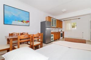a kitchen with two beds and a table and chairs at Victoria House Pefkohori 3 bedrooms 12 guests in Pefkohori