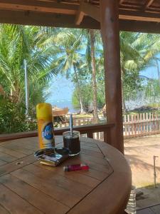 una mesa con una botella de aceite y una bebida en ella en JN Cottage dan Camping Ground en Karimunjawa