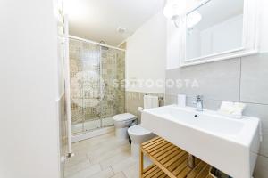 łazienka z białą umywalką i toaletą w obiekcie InCentro b&b w mieście Porto Cesareo