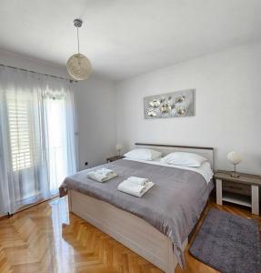 a bedroom with a large bed with two towels on it at Apartment GIDAS in Zadar