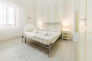 ein weißes Schlafzimmer mit einem Bett und einem Tisch in der Unterkunft InCentro b&b in Porto Cesareo