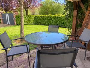 una mesa de cristal y sillas en un patio en Simple et sympa, en Vibeuf