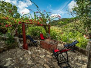 eine Terrasse mit Stühlen und einem Pavillon mit Blumen in der Unterkunft 1 bedroom cabin, 3 blocks from beach and center of San Juan in San Juan del Sur
