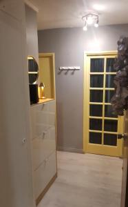 a room with a yellow door and a mirror at Studio Nimes - Clim - Wifi -Cuisine privatif - salle de bain commune- balcon in Nîmes +33 photos