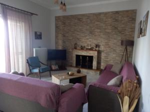 a living room with a purple couch and a fireplace at Σπίτι δίπλα στην θάλασσα in Patra