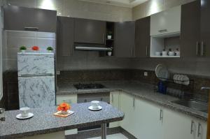 kuchnia z białymi szafkami i blatem w obiekcie appartement avec fontaine w mieście Benguerir