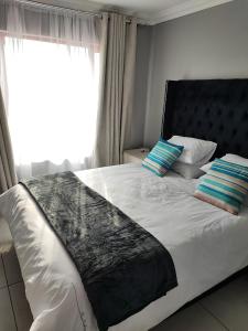 a bedroom with a large bed with a window at Kyalami Boulevard Estate, Kyalami Hills ext 10 Robin Road Midrand in Midrand