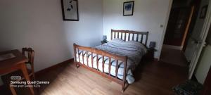małe łóżko w pokoju z drewnianą podłogą w obiekcie GITE LES MYOSOTIS w mieście Le Chambon-sur-Lignon