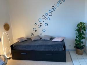 een slaapkamer met een bed met een blauwe muur bij Cocon de Rueil-Malmaison in Rueil-Malmaison