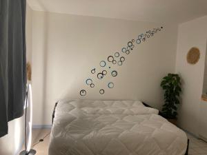 een slaapkamer met een bed en een muur met cirkels bij Cocon de Rueil-Malmaison in Rueil-Malmaison