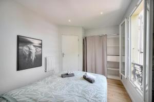 Un dormitorio con una cama y una ventana grande. en Le Érvé-350M Plage-Wifi Clim-VCA, en Cannes
