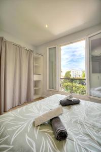 Un dormitorio con una cama grande con ventana. en Le Érvé-350M Plage-Wifi Clim-VCA, en Cannes