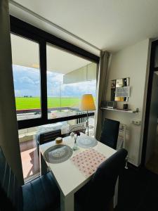 a dining room with a table and a large window at Messe Apartment Köln West in Cologne