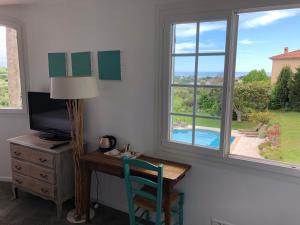 Habitación con escritorio, TV y ventana. en Villa Antoline en Cagnes-sur-Mer