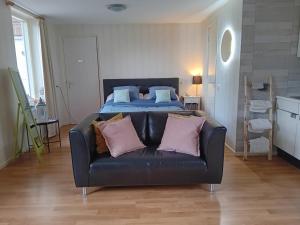 Bed & Breakfast in ons Bakhuis في أبلدورن: أريكة سوداء في غرفة مع سرير