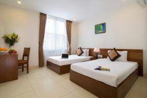 Postel nebo postele na pokoji v ubytování Golden Light Da Nang Hotel