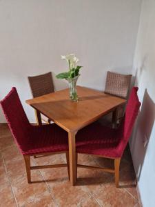 drewniany stół z krzesłami i wazon z kwiatami w obiekcie Stan na dan Dunja w mieście Herceg Novi