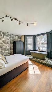 a bedroom with a large bed and a bath tub at INNit Bliss in Brighton & Hove