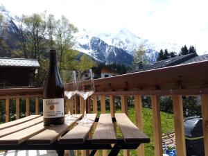 a bottle of wine and a glass on a wooden bench at Sauna Bain Nordique Cinéma Vue Montange in Chamonix