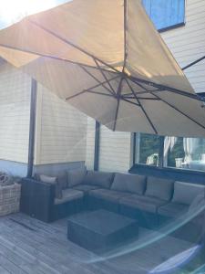 a large umbrella over a couch on a patio at Cozy Holiday Home with Outside Jacuzzi in Espoo