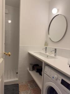 ein Badezimmer mit einer Waschmaschine und einem Spiegel in der Unterkunft Cœur d'Arles in Arles