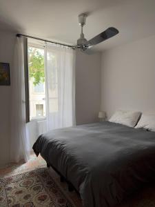 ein Schlafzimmer mit Bett und Deckenventilator in der Unterkunft Cœur d'Arles in Arles