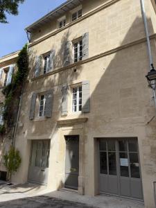 ein Gebäude mit Türen und Fenstern auf einer Straße in der Unterkunft Cœur d'Arles in Arles + 9 Fotos