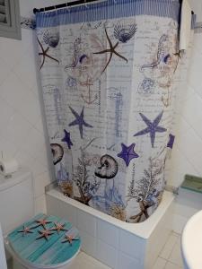 a bathroom with a shower curtain with a toilet at Hostal Santa Gemma in Sant Vicenç de Montalt