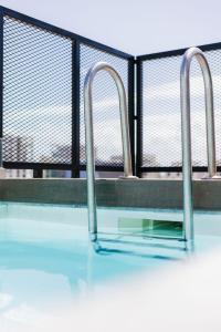 a swimming pool with two bars on top of it at Eleven by Warren Collection in Sliema