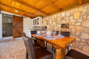 ein Esszimmer mit einem Holztisch und Stühlen in der Unterkunft Didovi dvori in Seline