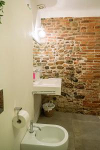 a bathroom with a sink and a brick wall at Antica Casa Dei Rassicurati in Montecarlo