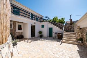 eine Terrasse mit einer Treppe und ein Haus in der Unterkunft Didovi dvori in Seline