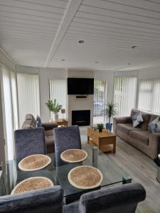 uma sala de estar com uma mesa e cadeiras e um sofá em Windermere lodge,sleeps 6 em Windermere