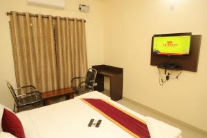 Habitación con cama y TV en la pared. en Hotel Shri Durga International, en Bangalore