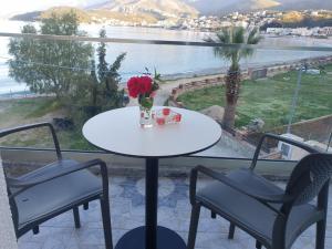 uma mesa e cadeiras numa varanda com vista para a água em Seaside Hotel em Himare