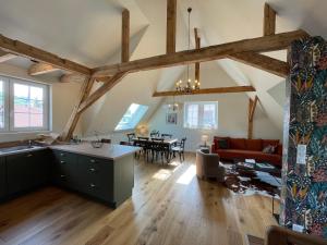 cocina y sala de estar con vigas de madera. en Le Hêtre Rouge Charme & Spa en Barr