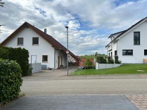 una casa bianca sul lato di una strada di TOP Ferienwohnung a Bad Urach