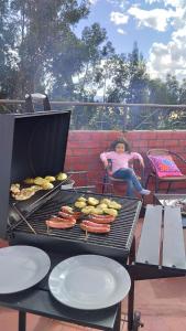 a little girl sitting on a grill with some food at Weninger Lodge in Urubamba